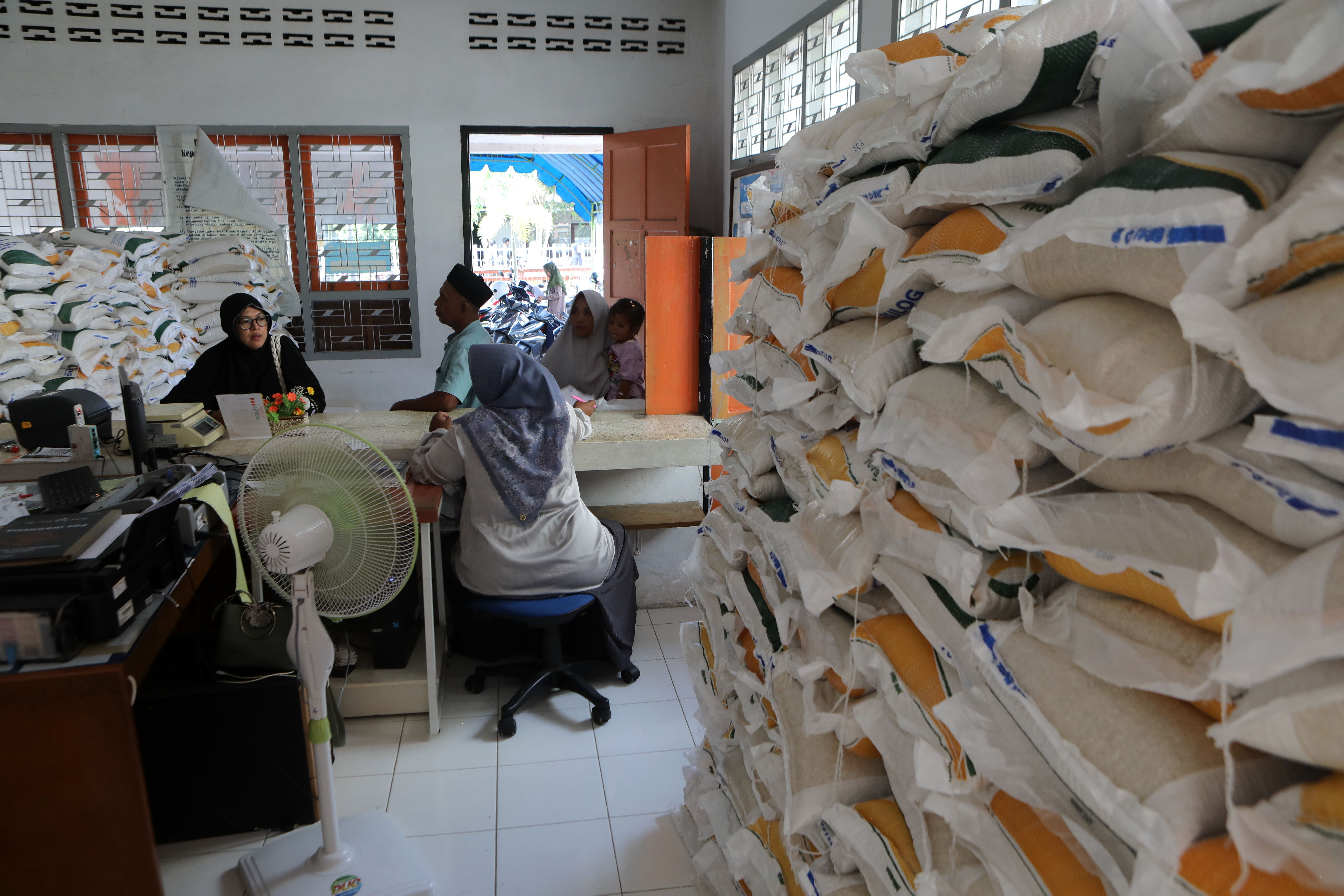 Residents receive food aid during a distribution drive in Indonesia. The Indonesian government is considering extending its rice handout scheme. PHOTO: EPA