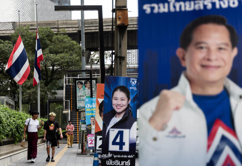 Commuters in Bangkok pass campaign posters ahead of Thailand’s February 8 election. With the country eyeing its fourth leader in three years, can this vote finally break the political cycle and spark an economic revival?